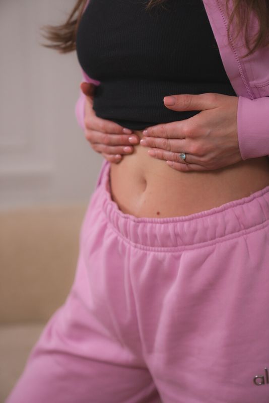 Mains pos&eacute;es sur le ventre, geste d'automassage